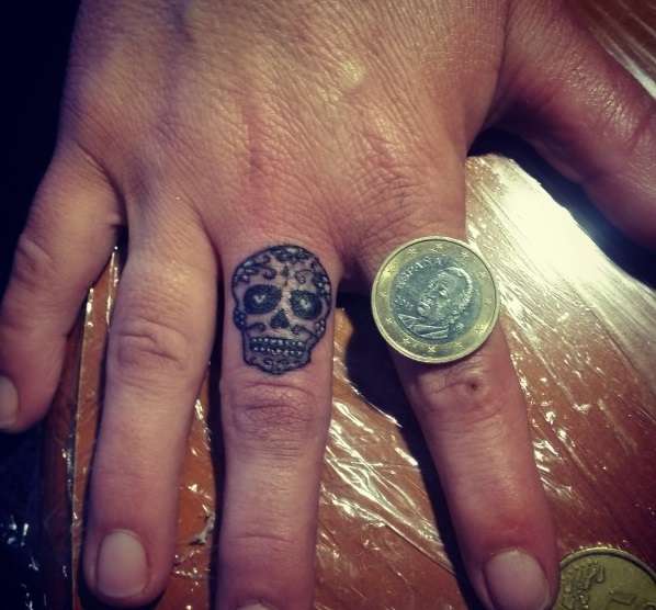 Tatuaje de calavera mexicana en dedo