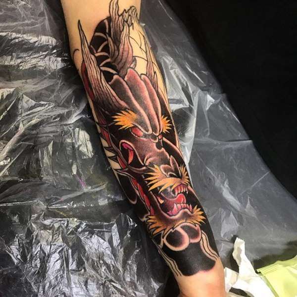 Tatuaje de dragón negro en el brazo