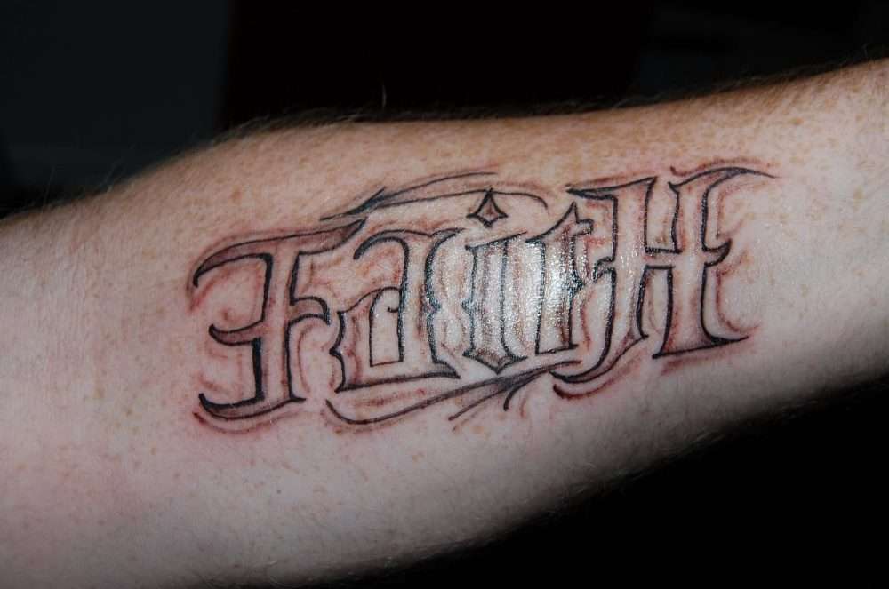 Tatuaje palabra Fe en antebrazo
