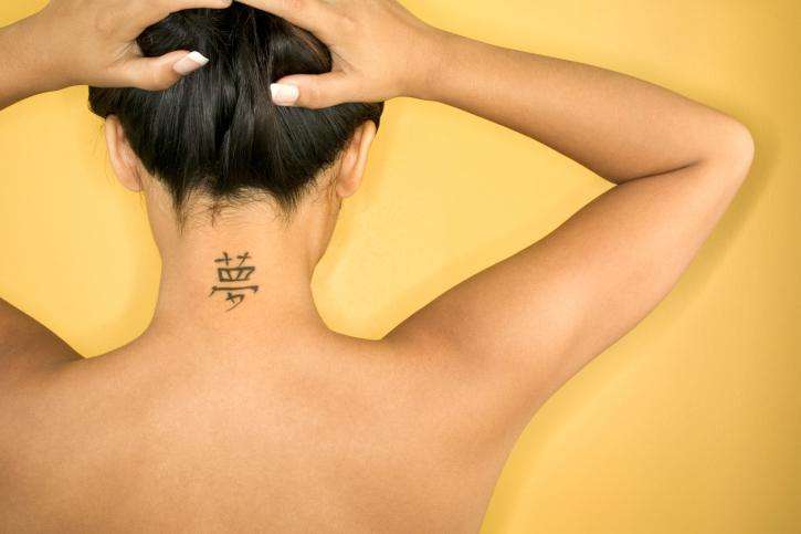Tatuaje pequeño - letras japonesas en la espalda