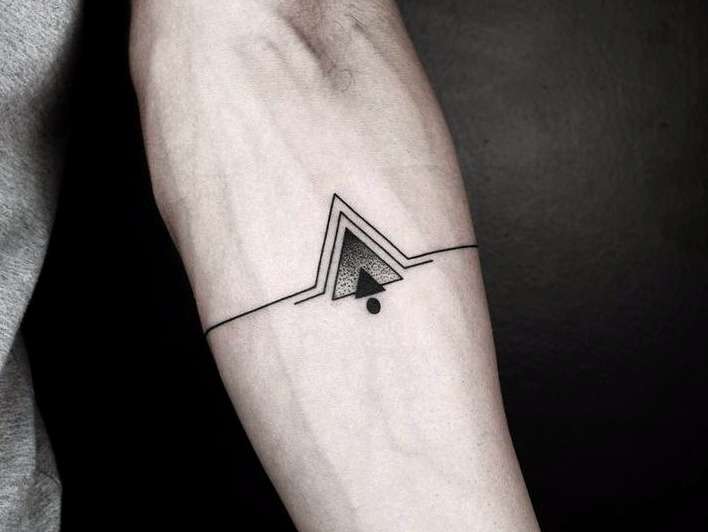 Tatuaje de símbolo pequeño en el brazo