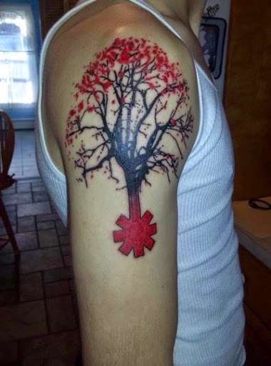 Tatuaje de árbol con detalles en rojo