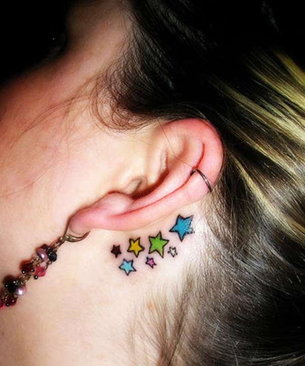 Tatuaje de estrellas en colores, detrás de la oreja