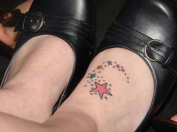 Tatuaje de estrellas de colores en el pie
