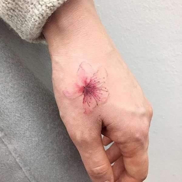 Tatuaje de flor de cerezo en la mano