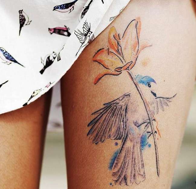Tatuaje en el muslo: ave y flor