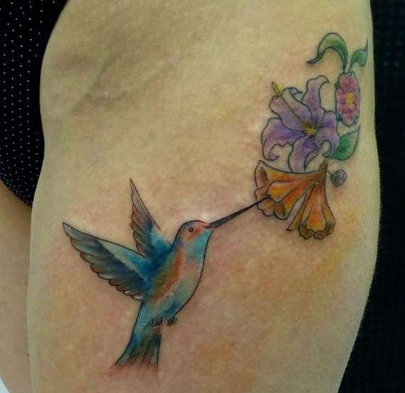 Tatuaje en el muslo: colibrí y flores