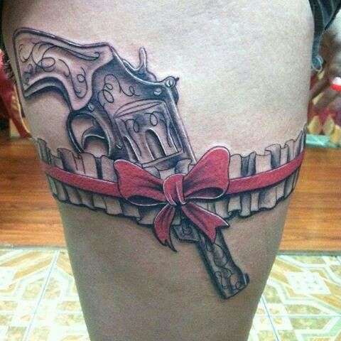 Tatuaje en el muslo - liguero y moño rojo - revólver