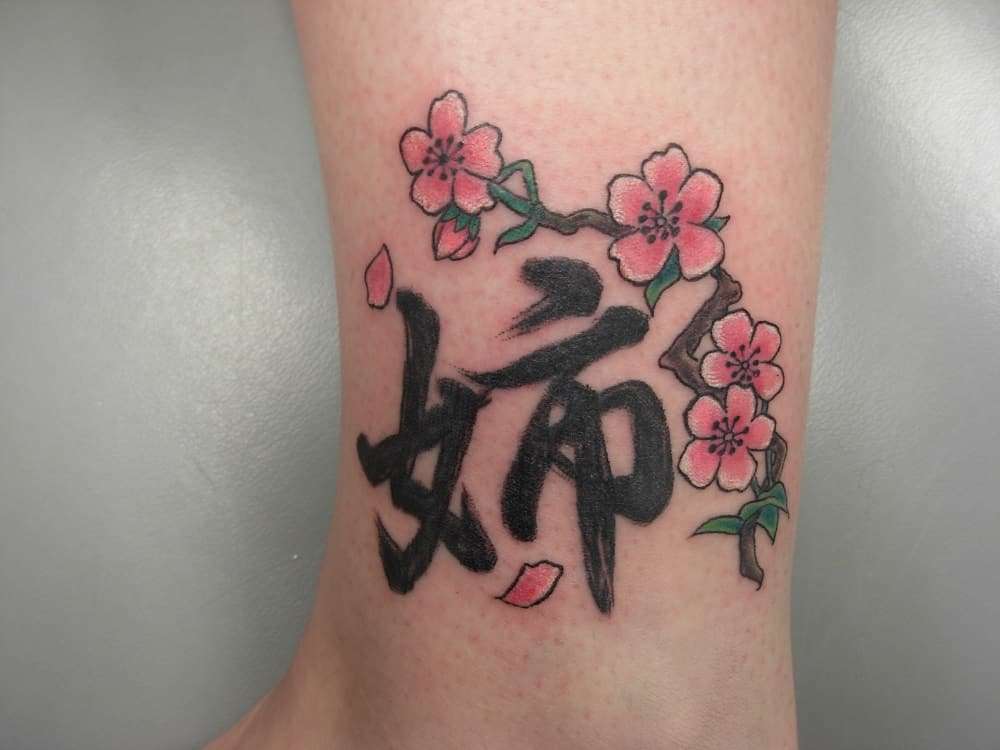 Tatuaje de flores de cerezo y letras