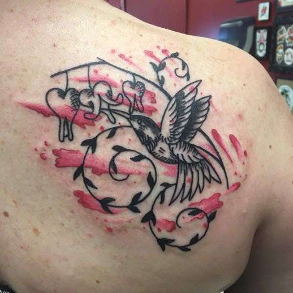 Tatuaje de colibrí con detalles en rojo