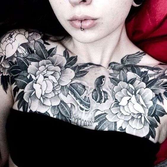Chicas sexis tatuadas, flores, calavera y serpiente en el pecho