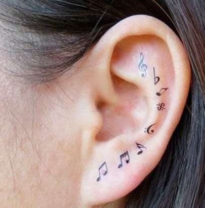 Tatuaje de notas musicales en la oreja