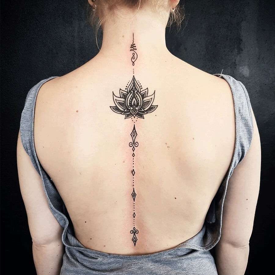 Tatuaje en la columna vertebral: flores y símbolos