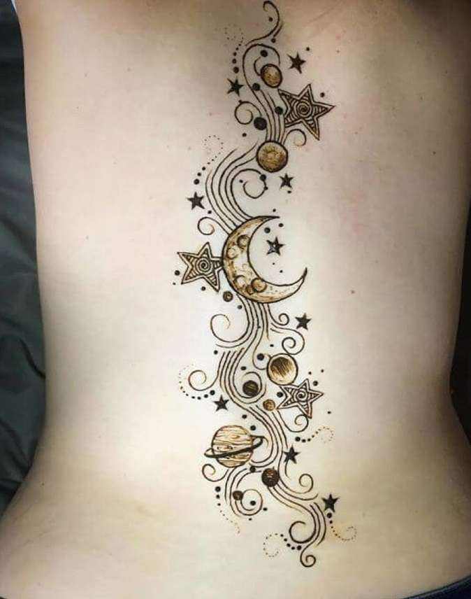 Tatuaje en la columna: luna, estrellas y planetas