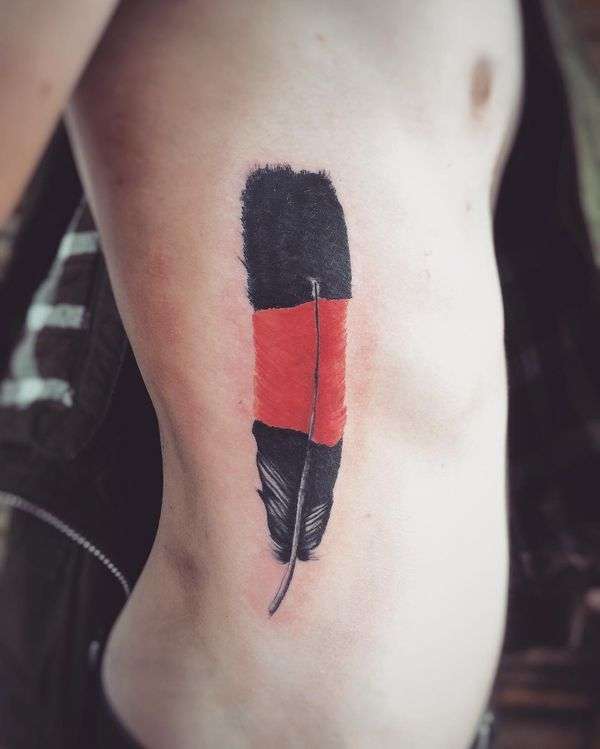 Tatuaje de pluma en rojo y negro
