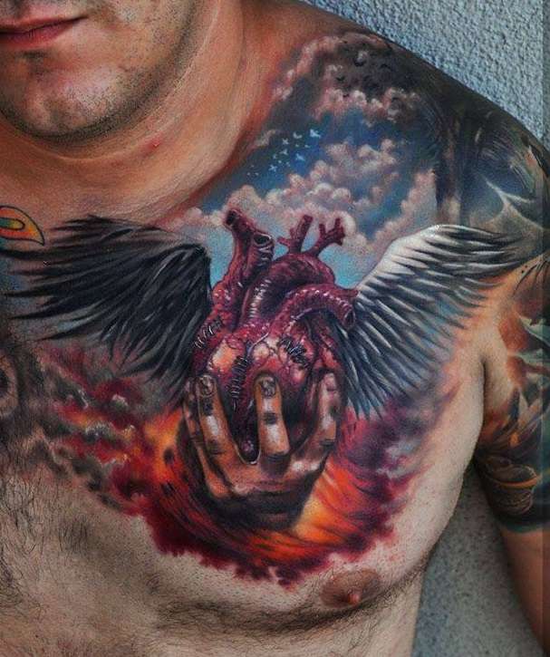 Tatuaje de corazón en una mano, con alas