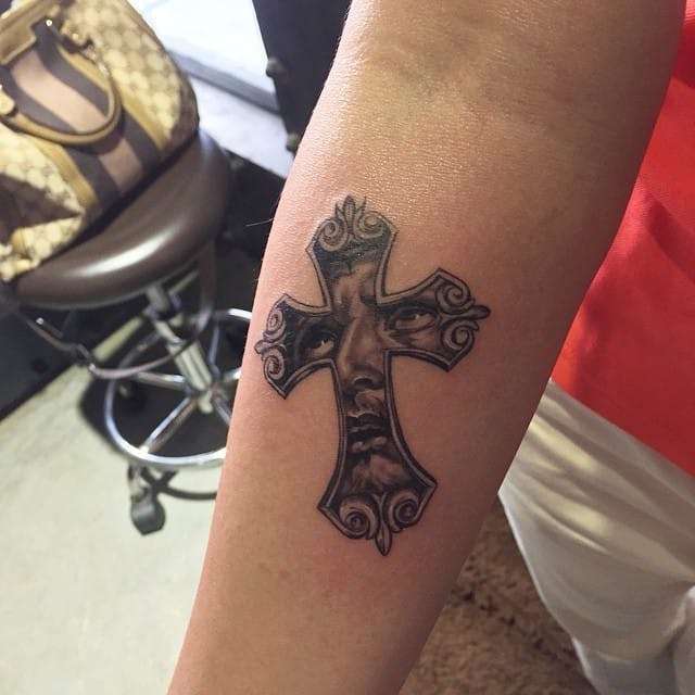 Tatuaje de cruz con el rostro de Cristo