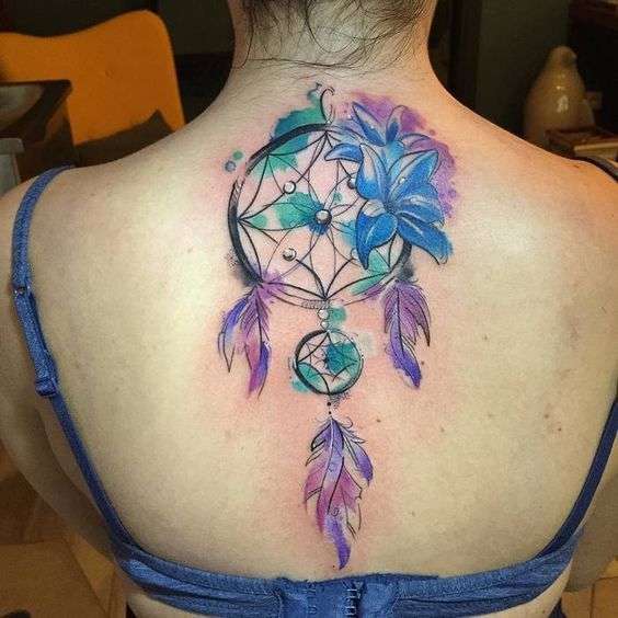 Tatuaje de atrapasueños con flores en la espalda