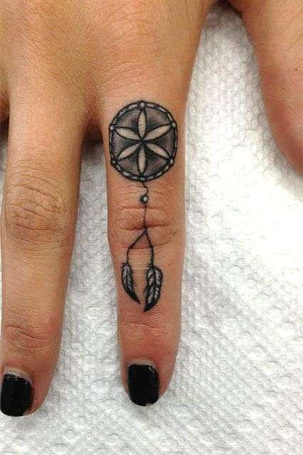 Tatuaje de atrapasueños pequeño en el dedo