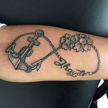 Tatuaje de infinito en blanco y negro, con ancla y flores