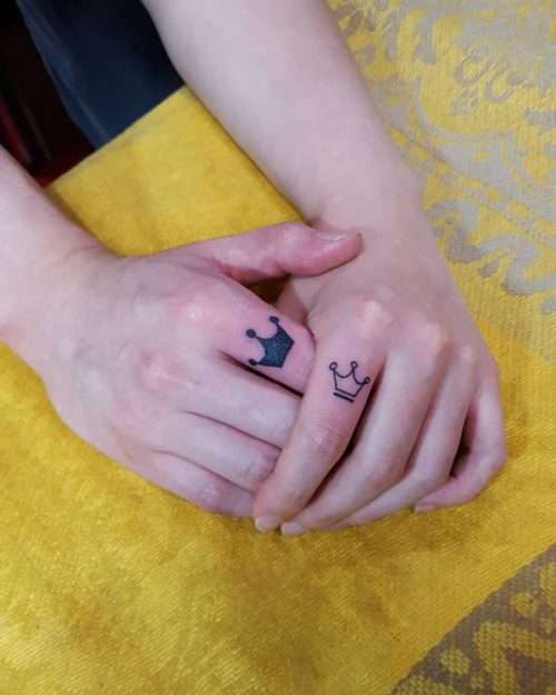 Tatuaje de coronas pequeñas en los dedos