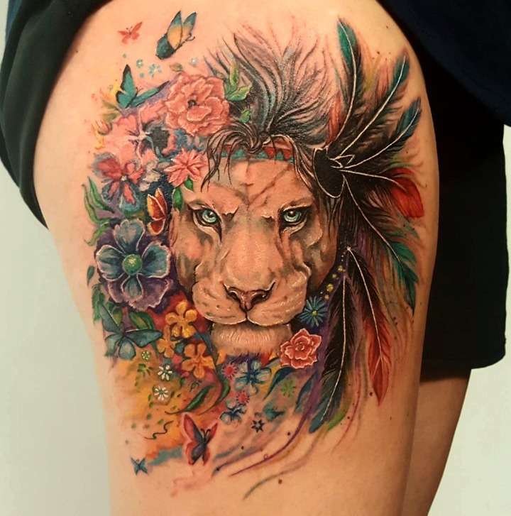 Tatuaje de león con flores y plumas