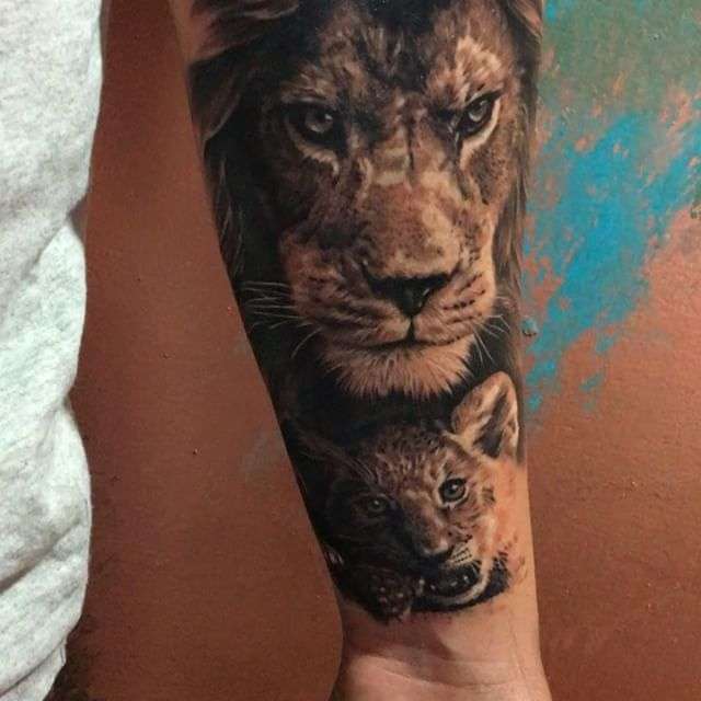 Tatuaje de león y cachorro en antebrazo