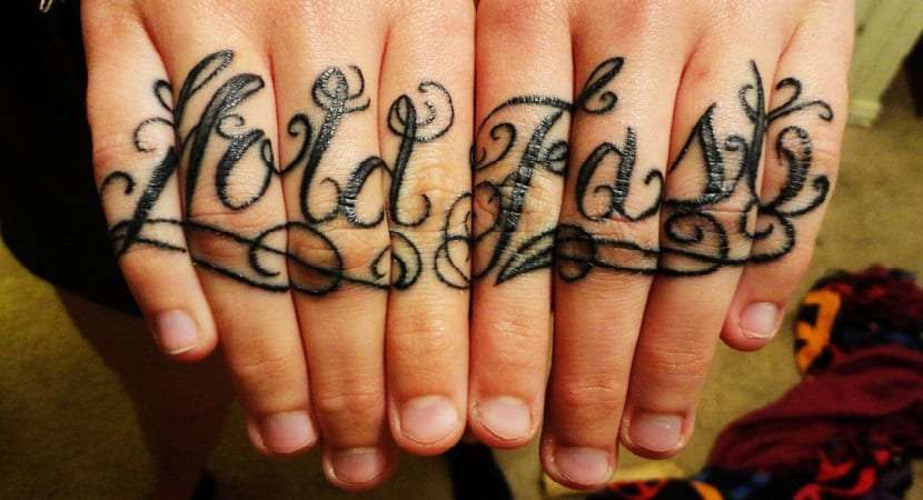 Tatuajes en los dedos: palabras en cursiva