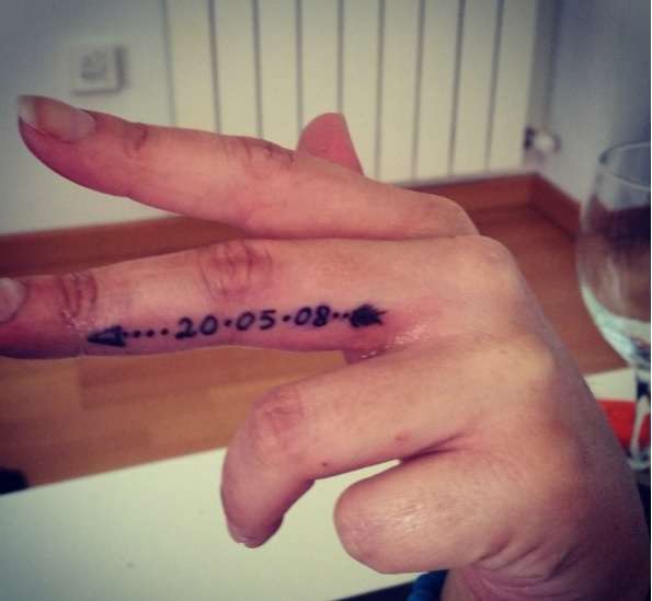 Tatuajes en los dedos: fecha y flecha