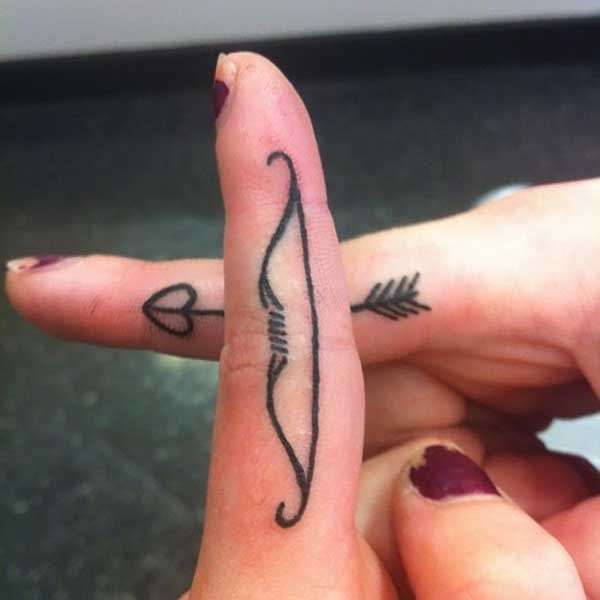 Tatuaje en los dedos: arco y flecha