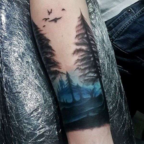 Tatuaje de bosque con toques de azul