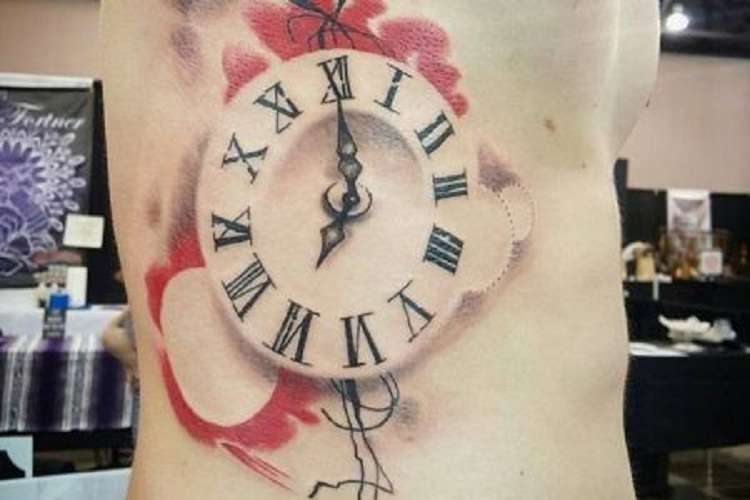 Tatuaje de reloj en el costado