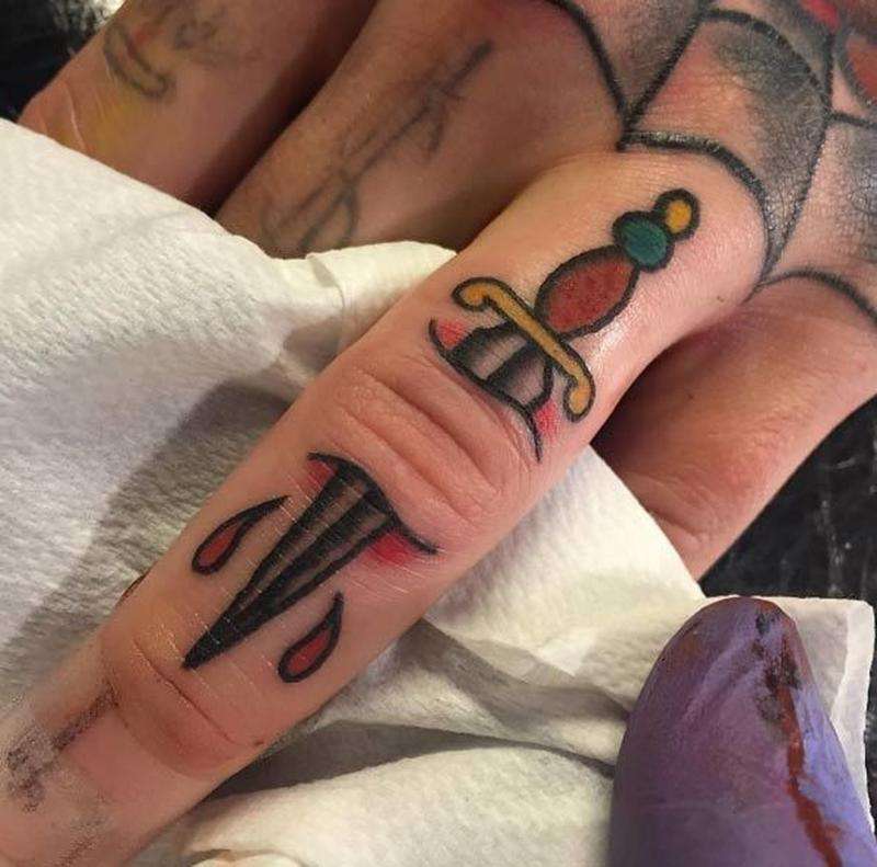 Tatuaje en los dedos: puñal en colores