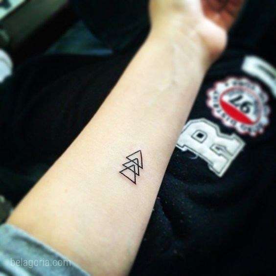 Tatuaje de triángulos pequeños en el antebrazo