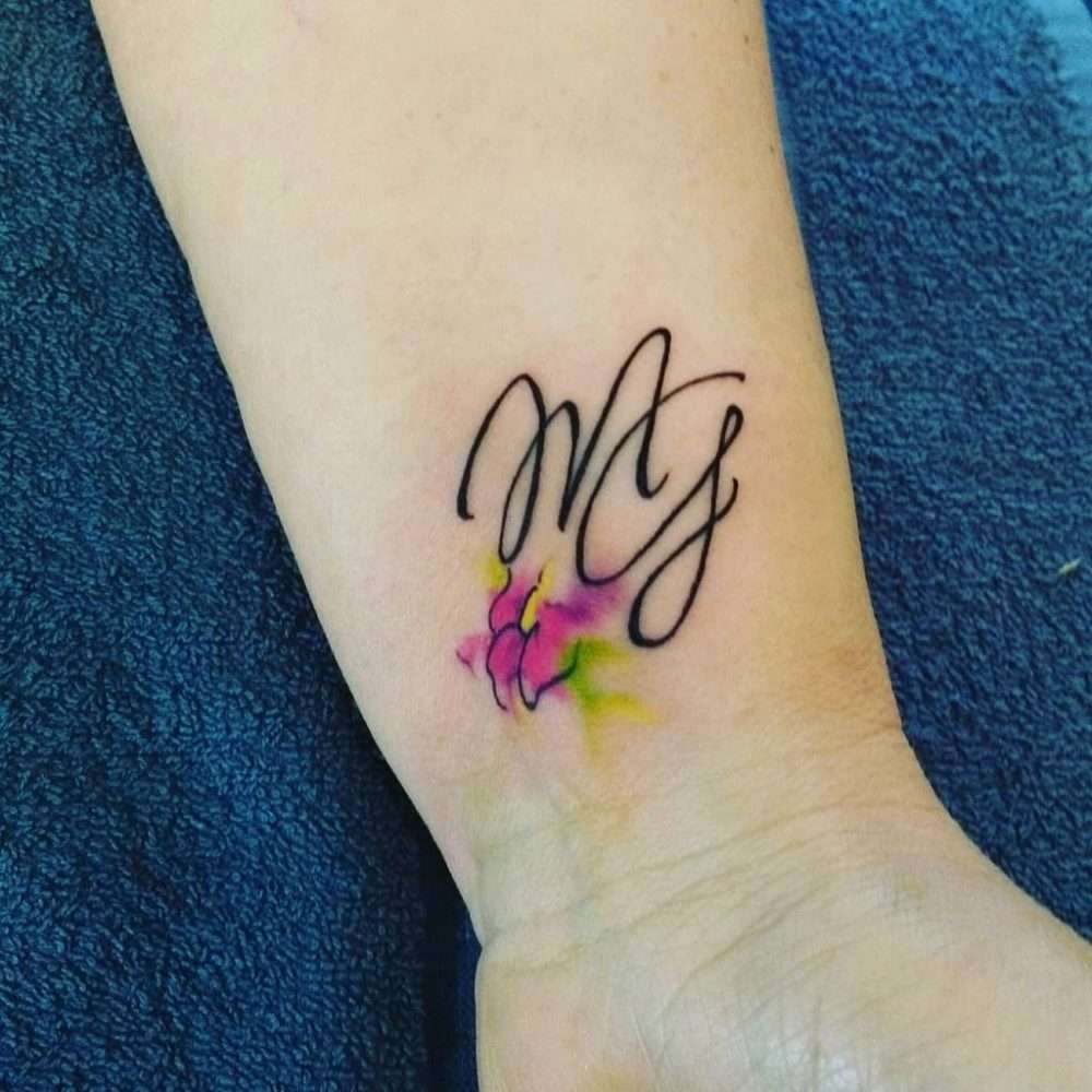 Tatuaje de letras y flor en acuarela