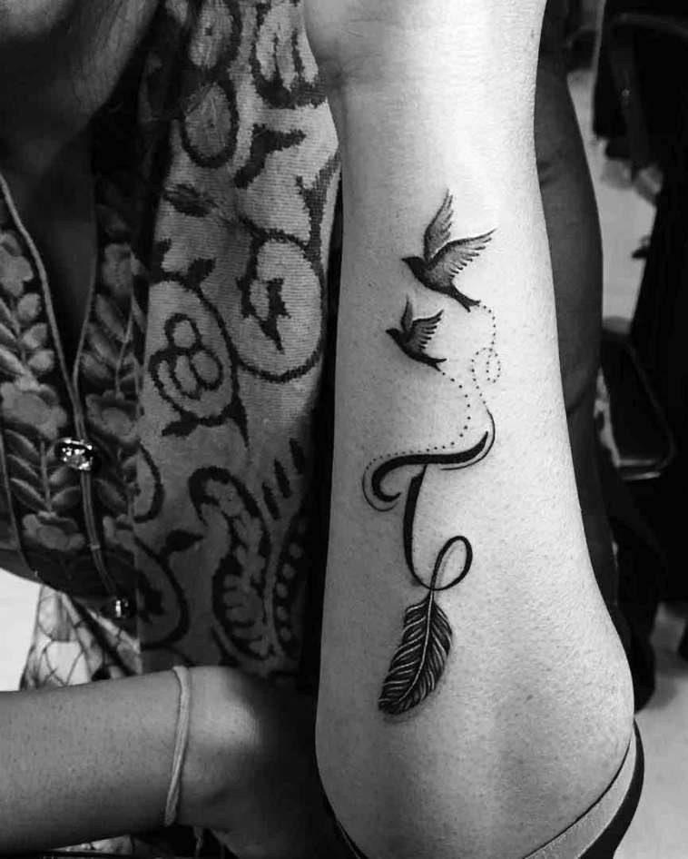 Tatuaje de letra "T" con pluma y aves