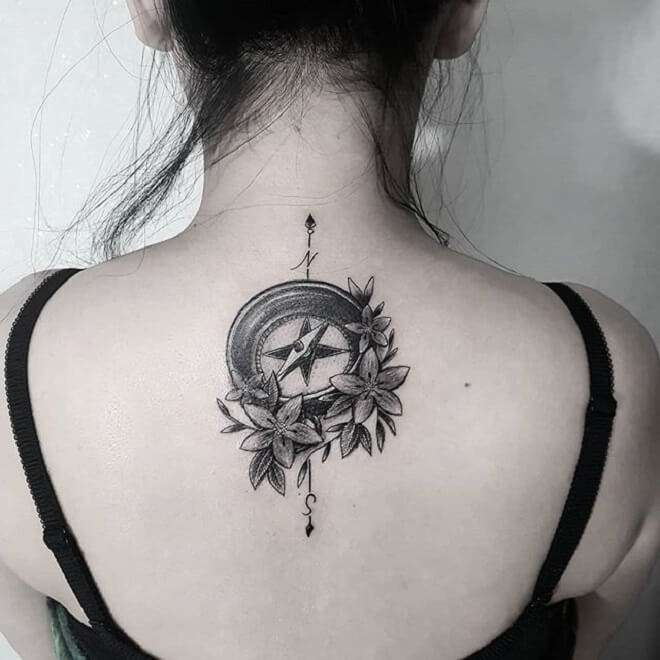 Tatuaje de brújula y flores en la espalda
