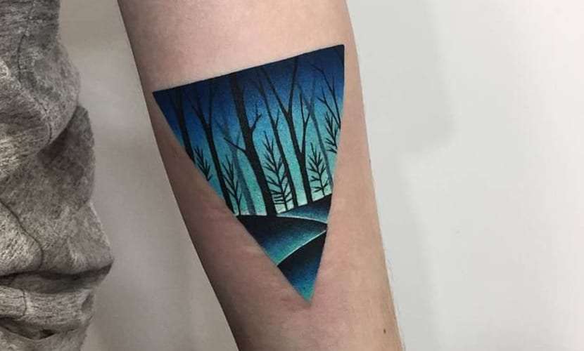 Tatuaje de triángulo con paisaje de bosque