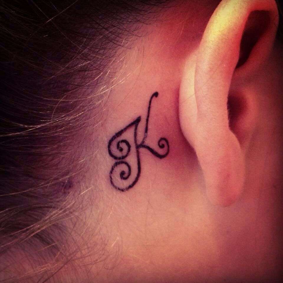 Tatuaje de letra "K" detrás de la oreja