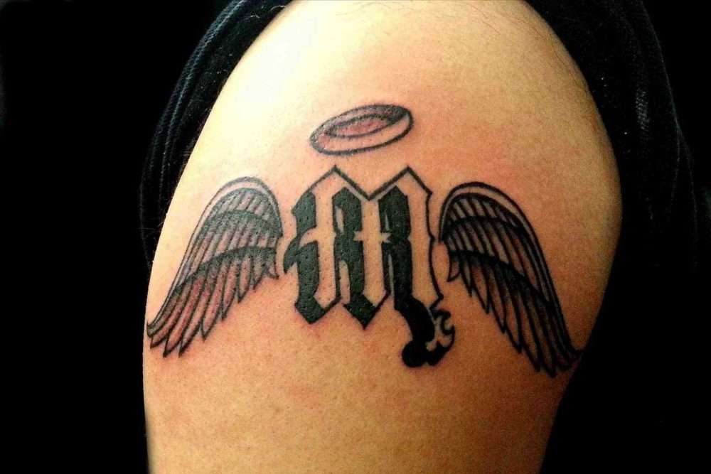 Tatuaje de letra "M" con alas de ángel