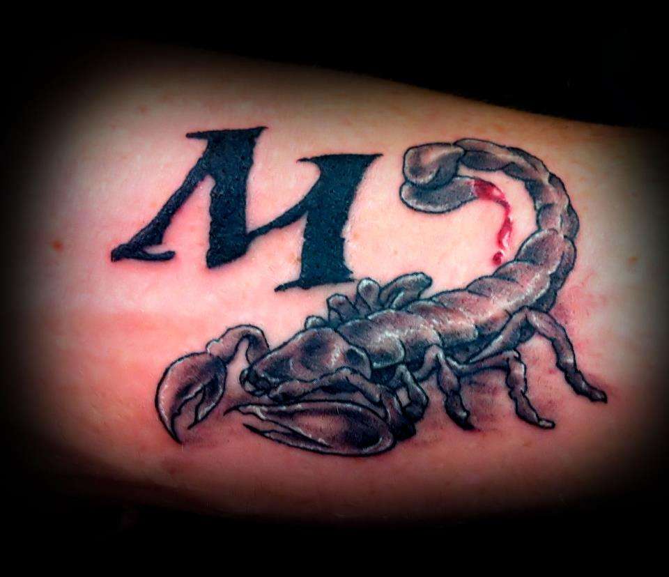 Tatuaje de letra "M" con un alacrán