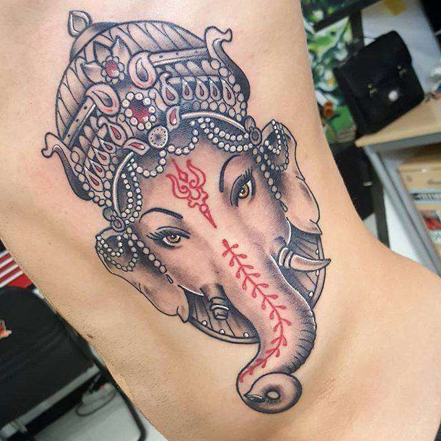 Tatuaje de elefante con detalles en rojo